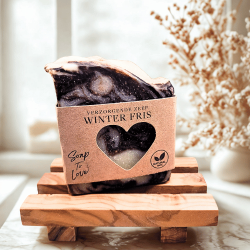 Donkerbruine handgemaakte winterzeep Winterfris met witte swirls op een houten zeepbakje