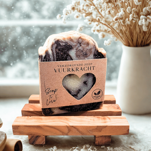 Zwarte handgemaakte winterzeep Vuurkracht met grijs-witte marmering op een houten zeepbakje